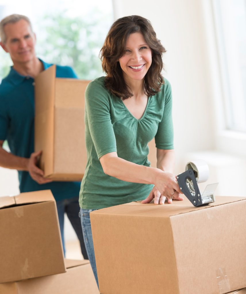 A couple with boxes, packing their house, getting ready to move.